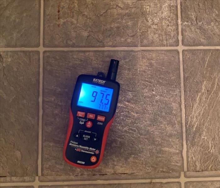 A moisture meter is used to evaluate how much water is present in a floor. 